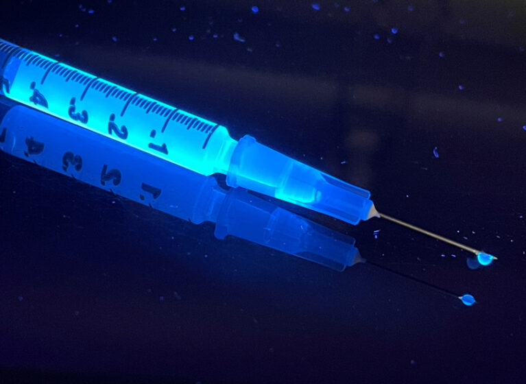 Harmine in a syringe, which glows under UV light.